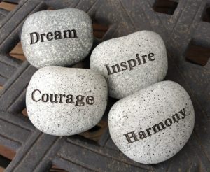 Rocks with the words Dream, Inspire, Courage and Harmony printed on them.