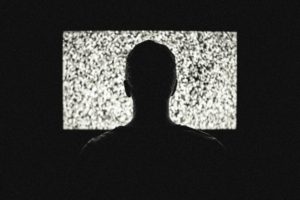 Person in silhouette of tv screen of white noise